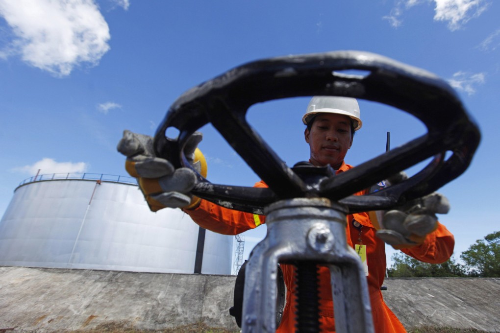 A PT Pertamina worker opens a gauge near crude oil tanks on Bunyu island, Indonesia’s East Kalimantan province. Photo: Reuters
