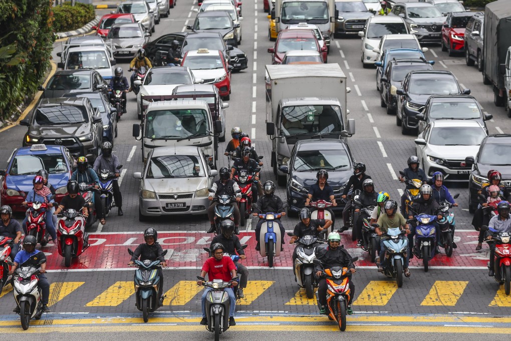 Commuters wait at a traffic light in Kuala Lumpur. Most residents commute by road in the city. Photo: EPA-EFE