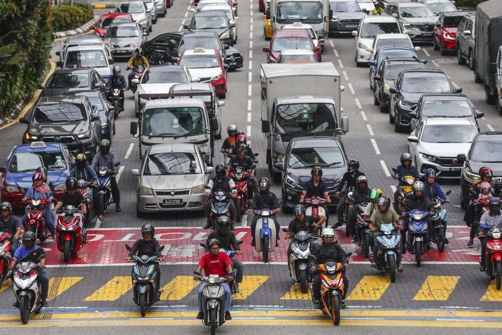 Commuters wait at a traffic light in Kuala Lumpur. Most residents commute by road in the city. Photo: EPA-EFE
