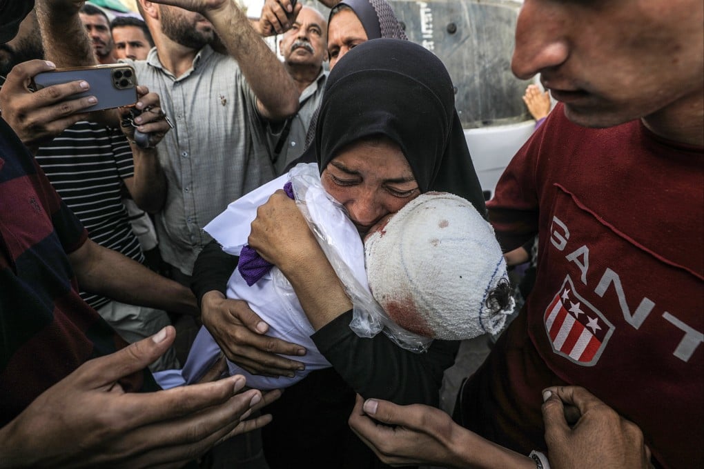 A Palestinian woman, grandmother of killed one-and-a-half-year old baby Yaman Al Zaneen, mourns while carrying his body during a funeral in the central Gaza Strip. Photo: EPA-EFE