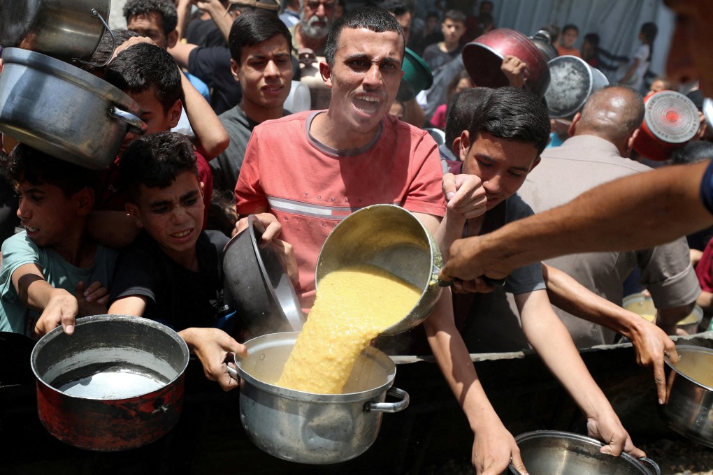 Palestinians wait to receive food cooked by a charity kitchen in Jabalia, in the northern Gaza Strip. Photo: Reuters