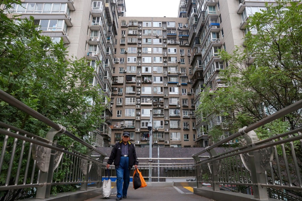 A man walks on a pedestrian bridge near residential buildings in Beijing in October 2024. Photo: Reuters