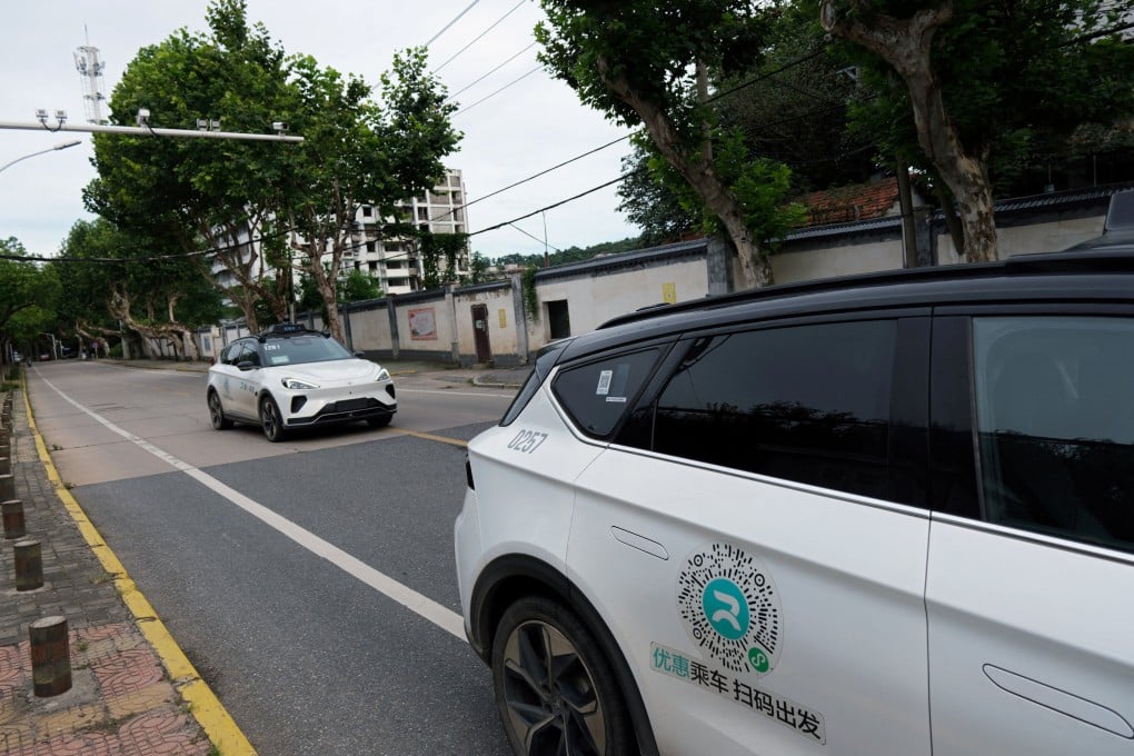 A driverless car by Apollo Go, Baidu’s robotaxi service, drives past another Apollo Go vehicle in Wuhan on July 19, 2024. Photo: Reuters