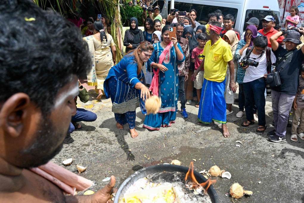 An Indonesian Hindu devotee smashes a coconut on the ground while participating in the last day of the traditional Chithirai Mahapuja procession in Banda Aceh on April 20. Photo: AFP
