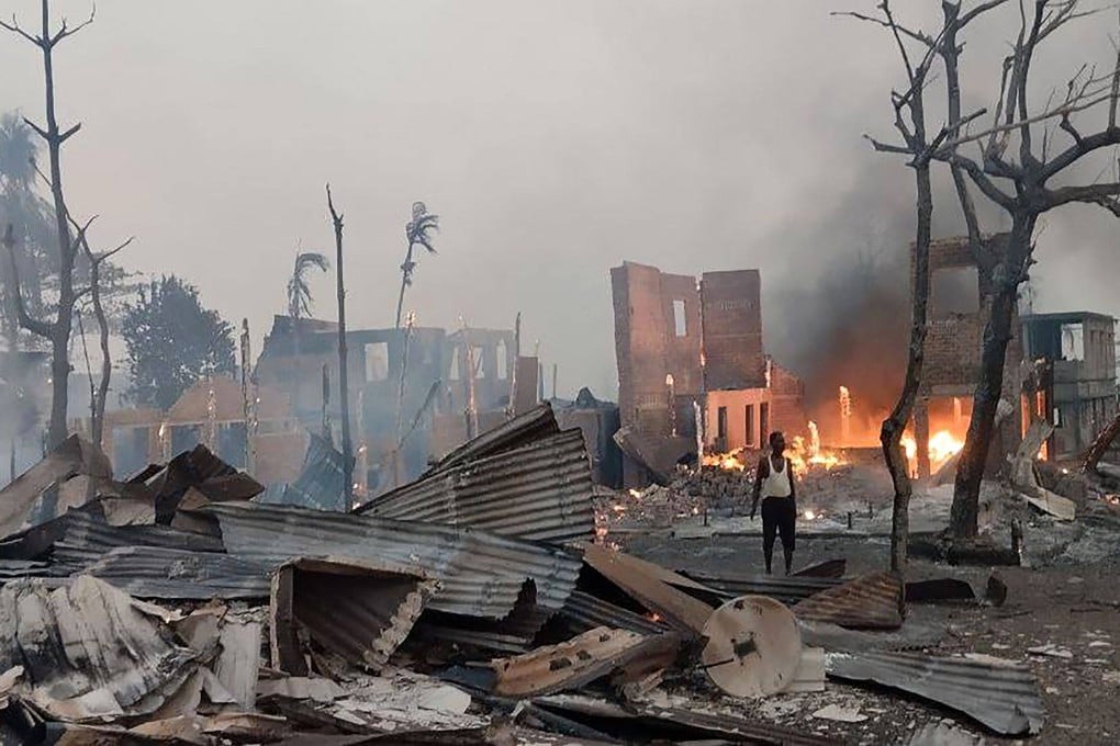 A man stands near a burning house at the site of a suspected air strike carried out by Myanmar’s military in Rakhine state in January. Photo: Arakan Army / AFP