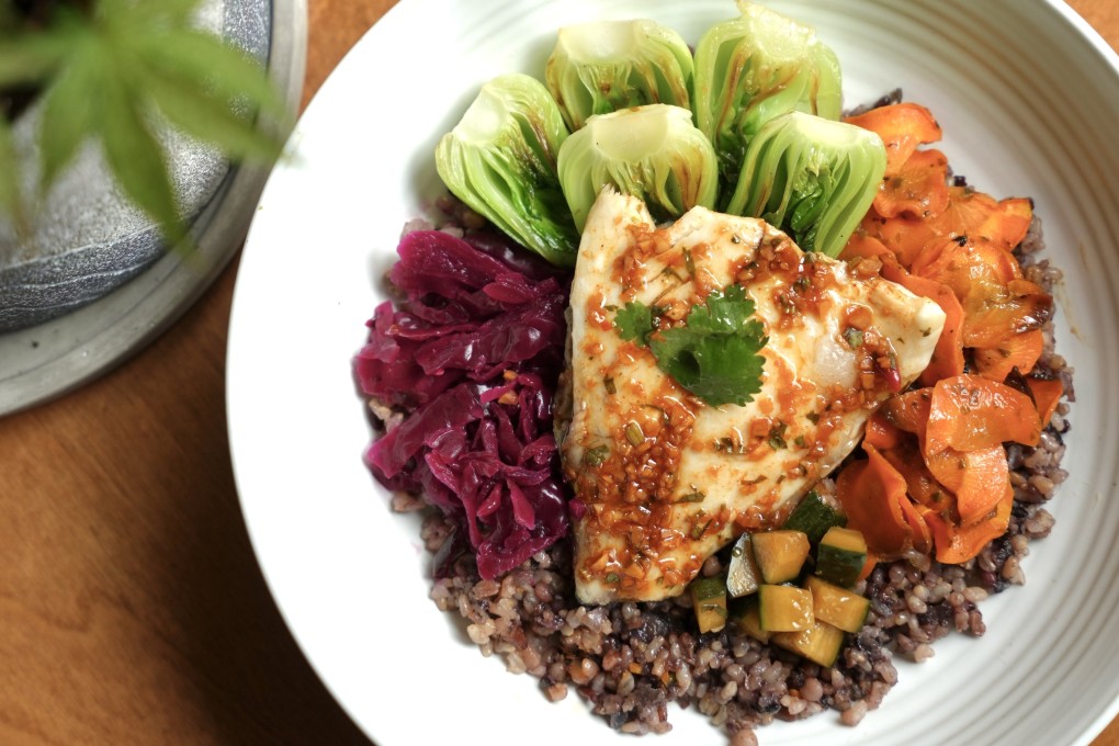 A dish from Hong Kong restaurant Gróa of herby gochujang market fish fillet, mixed grains, bok choy, jalapeño sauerkraut, honey carrots and pickled cucumber. Photo: Gróa