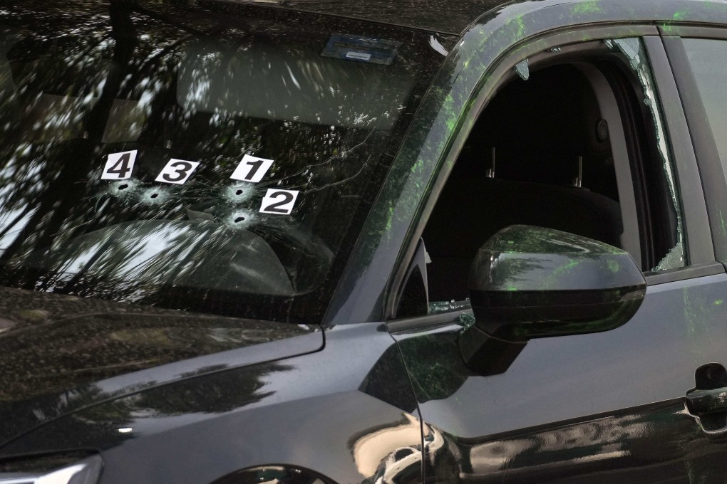 Bullet holes clustered on the driver’s side of the windshield. Photo: AFP