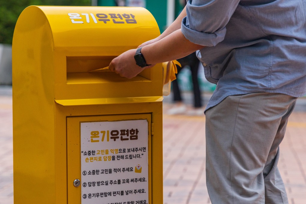 A man submits a letter to the “Warmth Mailbox” located on the campus of Konkuk University, western Seoul. Photo: Kim Jung-yeop