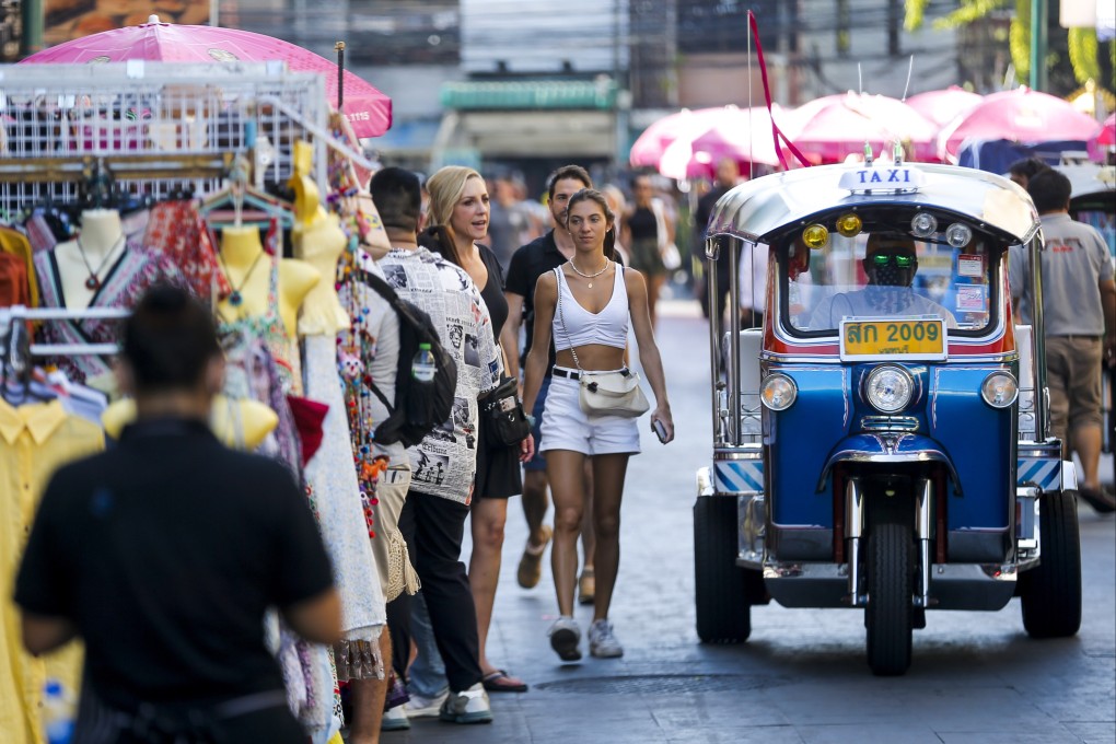 Tourists walk past a tuk tuk in a popular tourist area in Bangkok, Thailand. Photo: EPA-EFE