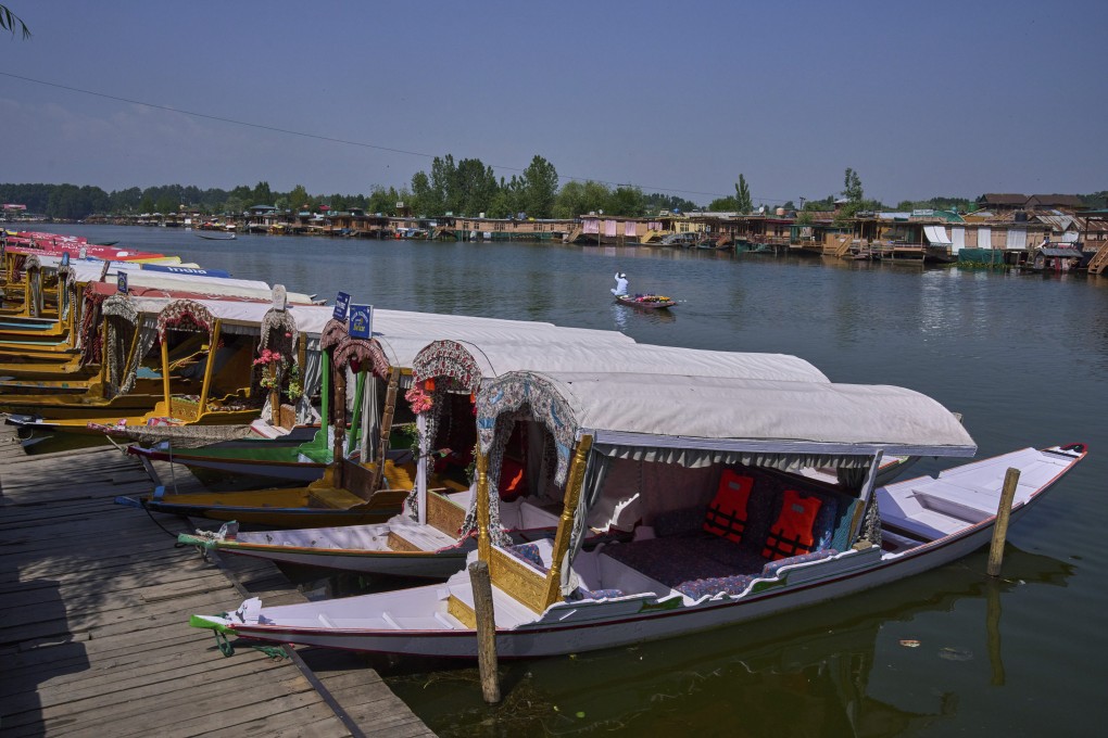 A flower vendor rows past anchored traditional wooden boats on Dal Lake in Srinagar, Indian-controlled Kashmir, on May 20. Photo: AP