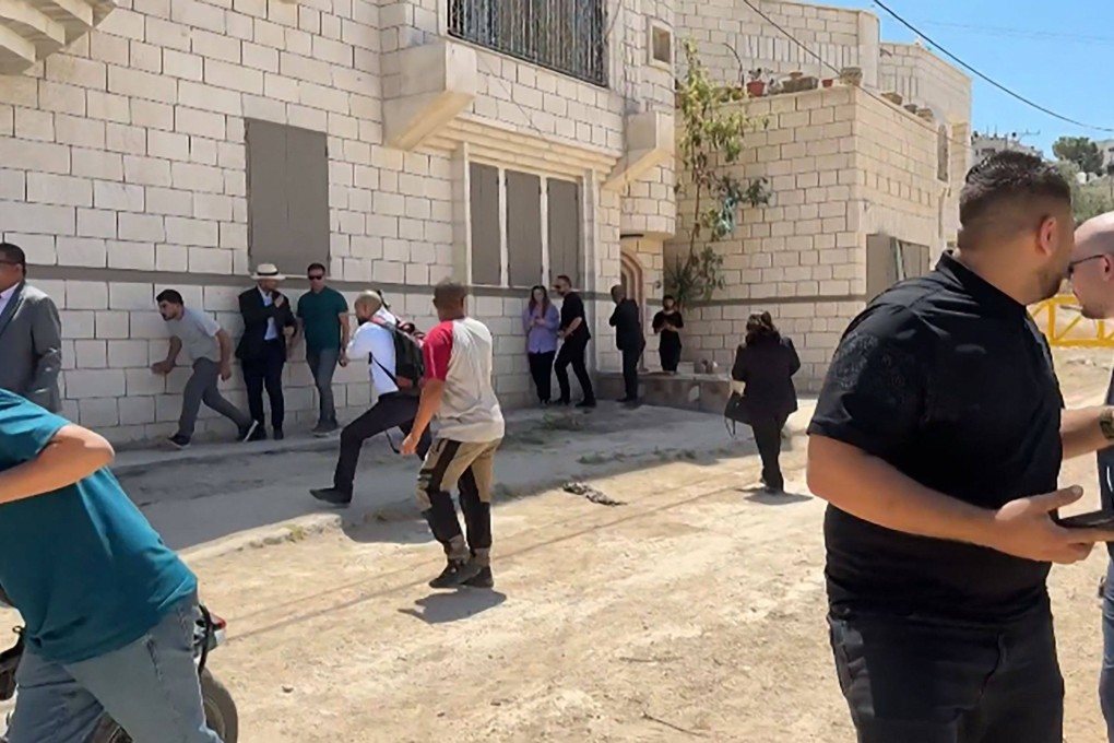 Members of a diplomatic delegation react after warning shots were fired in the distance. Photo: AFP