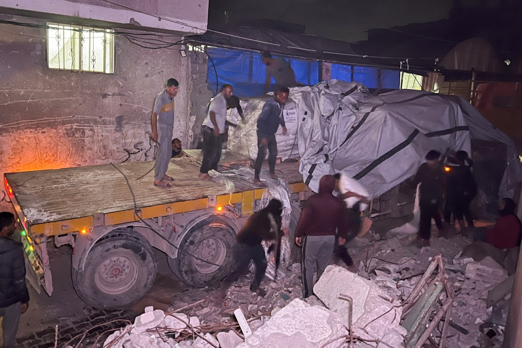 Palestinian workers unload sacks of flour from an aid truck at a bakery in Khan Younis on Wednesday. Photo: Reuters
