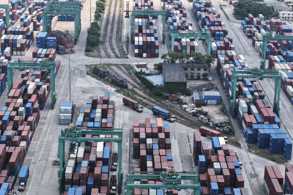 Trucks move past containers piled up at a container terminal, in Shanghai, China on May 14. Photo: Chinatopix via AP