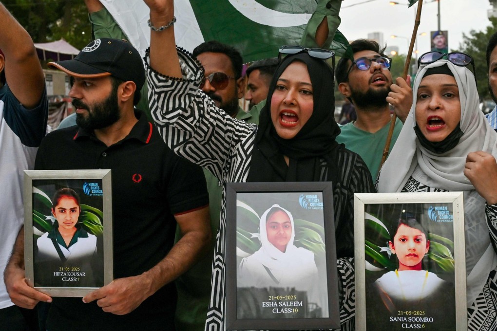 Human rights activist hold portraits of children killed in the school bus bombing in Balochistan, during a rally in Karachi on Wednesday. Photo: AFP