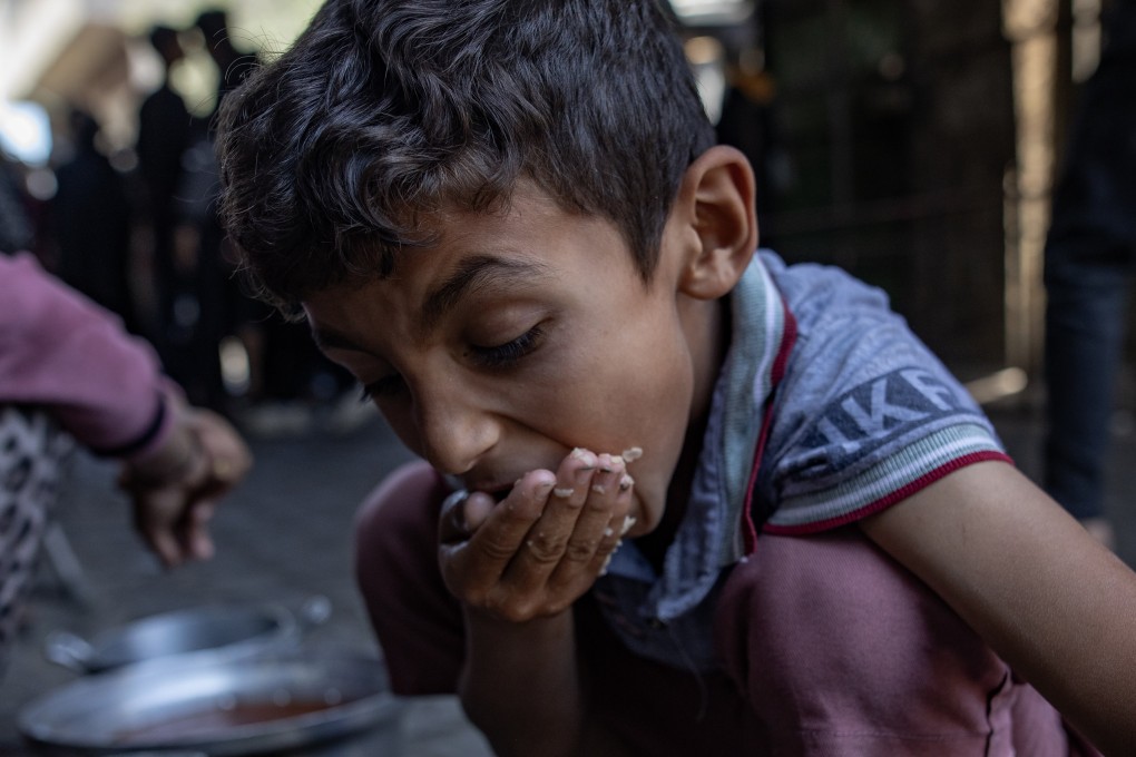 A child eats as displaced Palestinians gather to receive limited food rations in Gaza City on Wednesday. Photo: EPA-EFE