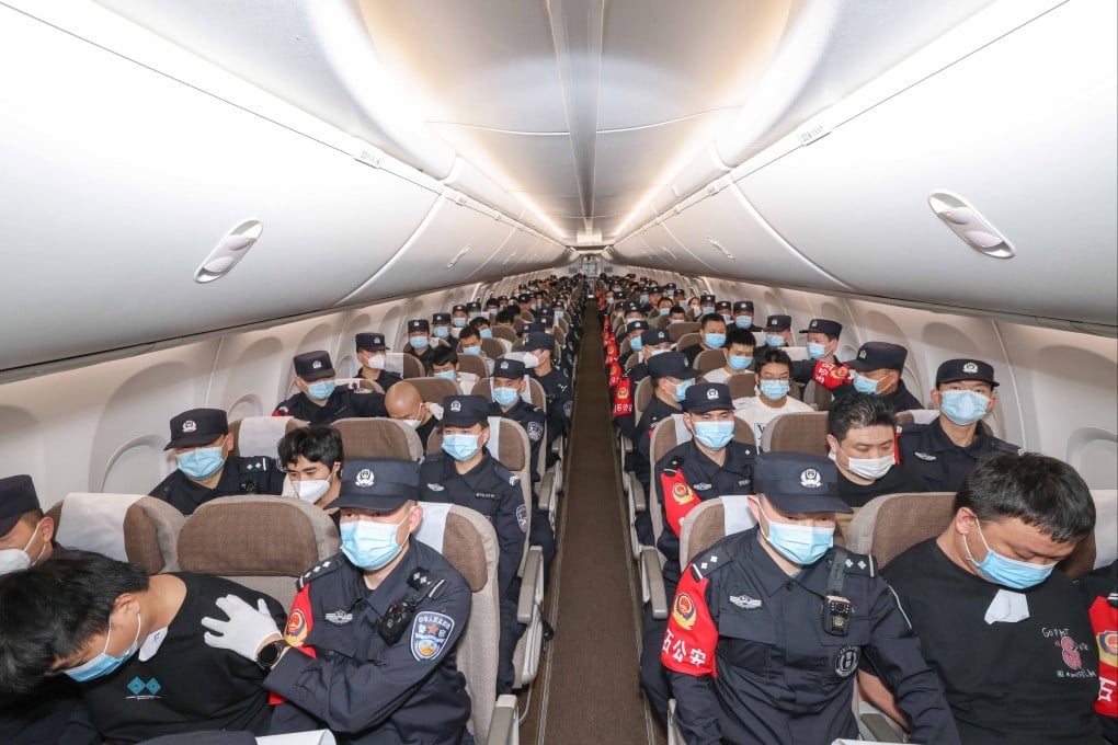 Scam suspects escorted by Chinese police officers in a flight from Cambodia last year. Photo: Xinhua