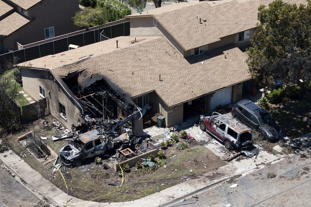 Debris covers the ground after a small plane crashed into a San Diego neighbourhood, setting homes and cars on fire. Photo: AP