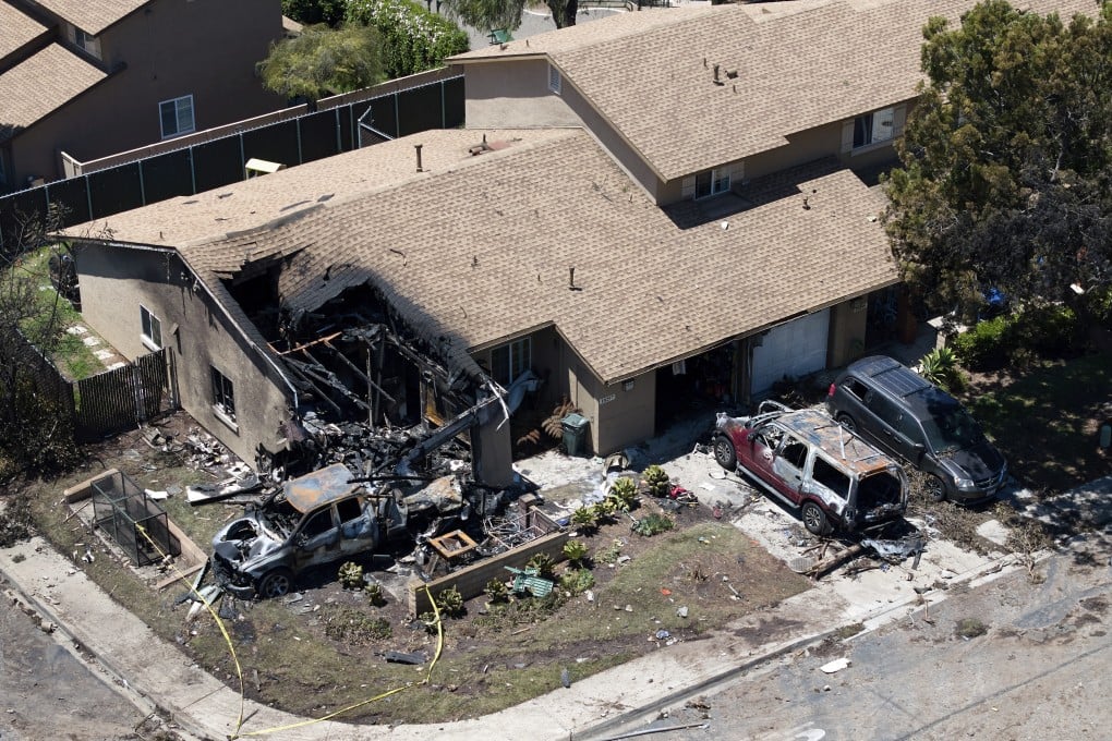 Debris covers the ground after a small plane crashed into a San Diego neighbourhood, setting homes and cars on fire. Photo: AP