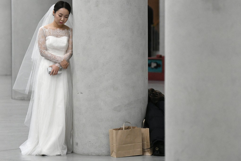 A bride leans on a pillar before a mass wedding ceremony organised by the South Korean Unification Church. Photo: AFP