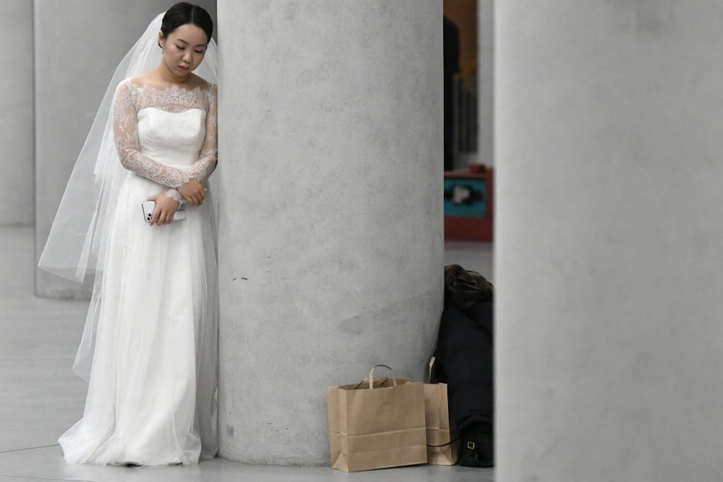 A bride leans on a pillar before a mass wedding ceremony organised by the South Korean Unification Church. Photo: AFP