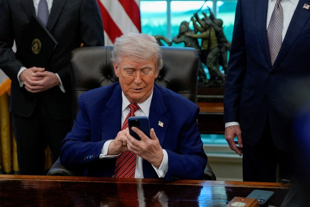 US President Donald Trump holds an iPhone after it rang while he was speaking at the White House, May 23, 2025. Photo: Reuters