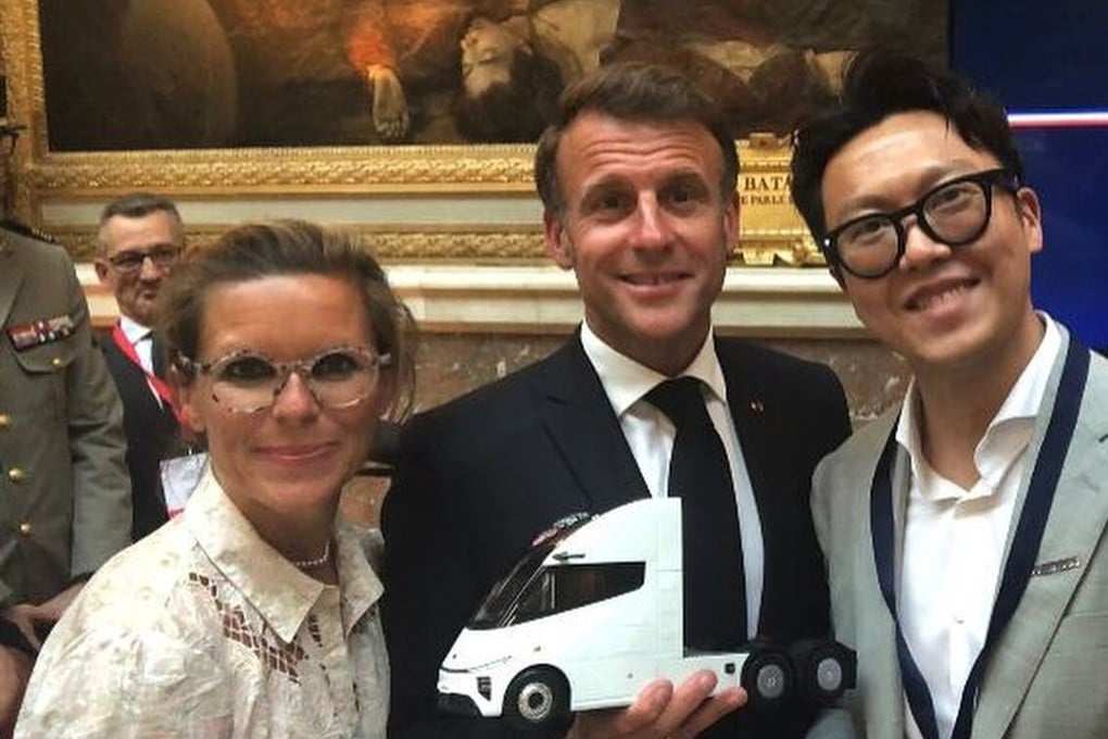 French President Emmanuel Macron (centre) holds a model of an electric lorry made by Windrose, a Chinese company founded by entrepreneur Wen Han (right), at the Choose France summit in Versailles, France on Monday. Photo: Instagram/whan6023