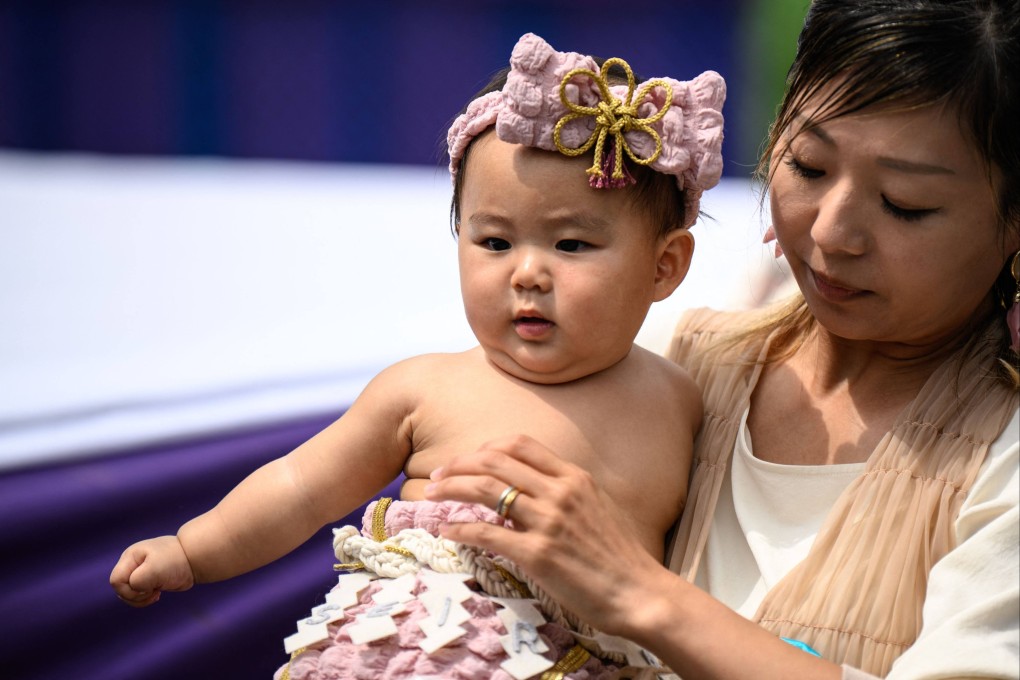 A parent holds her child during an event at Sensoji temple in Tokyo in April. Japan has begun enforcing a law aimed at curbing the rise of unconventional and sometimes bewildering baby names. Photo: AFP