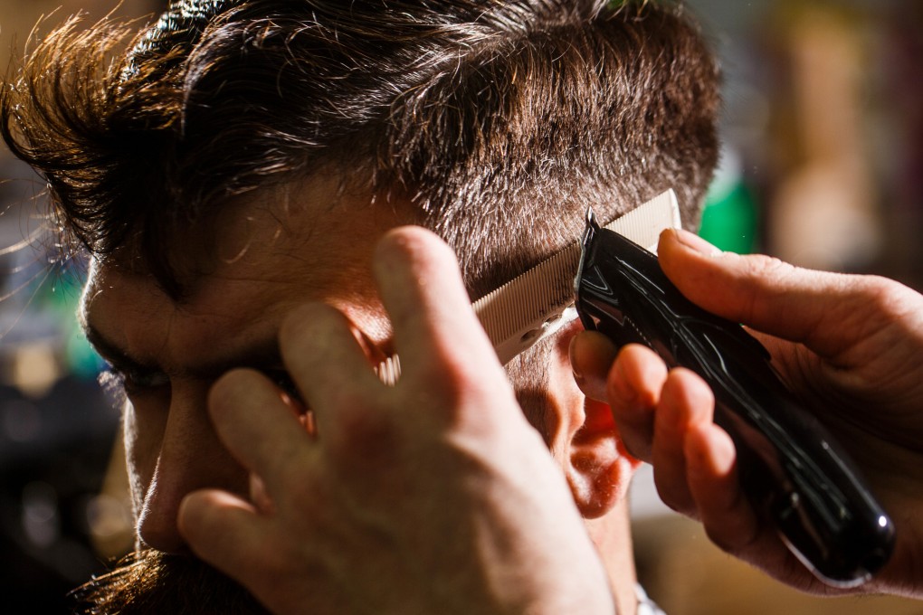 A barber giving a man a shave with hair clippers. A clerk in Kyoto was forced to shave his own head by an irate customer. Photo: Shutterstock
