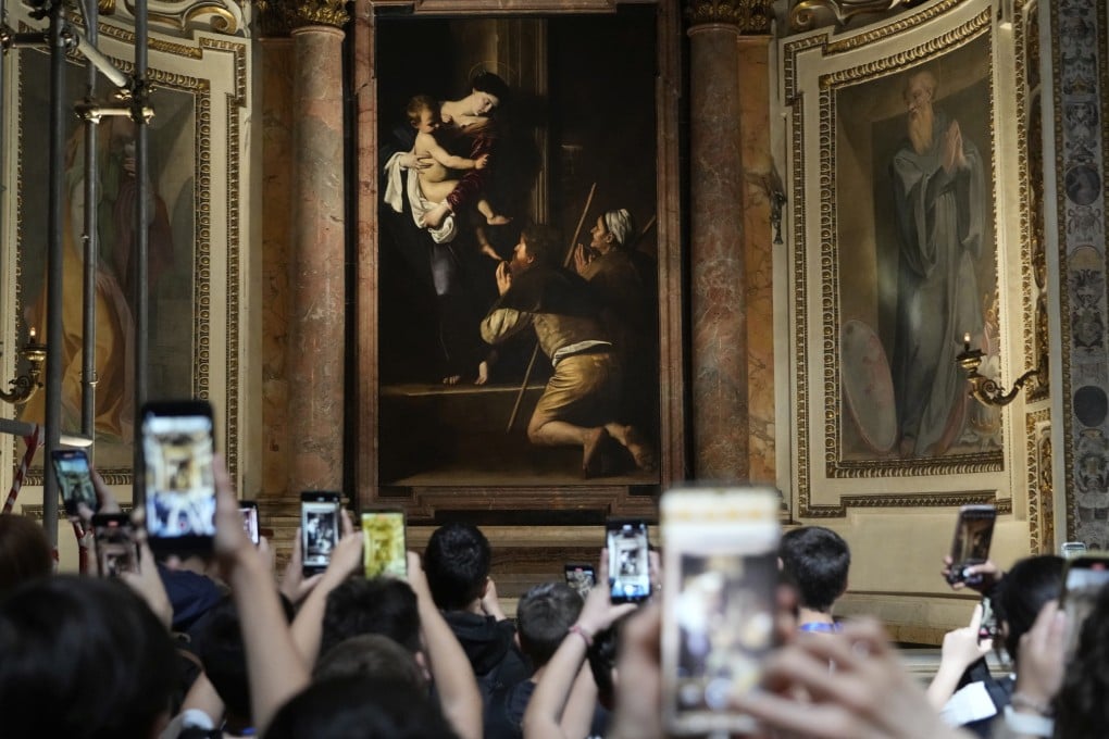 Tourists admire the Pilgrims’ Madonna by Caravaggio at the Basilica of St Augustine in Rome. As well as the examples of his art in Roman churches, a major Caravaggio exhibition continues at the city’s Palazzo Barberini until July. Photo: AP