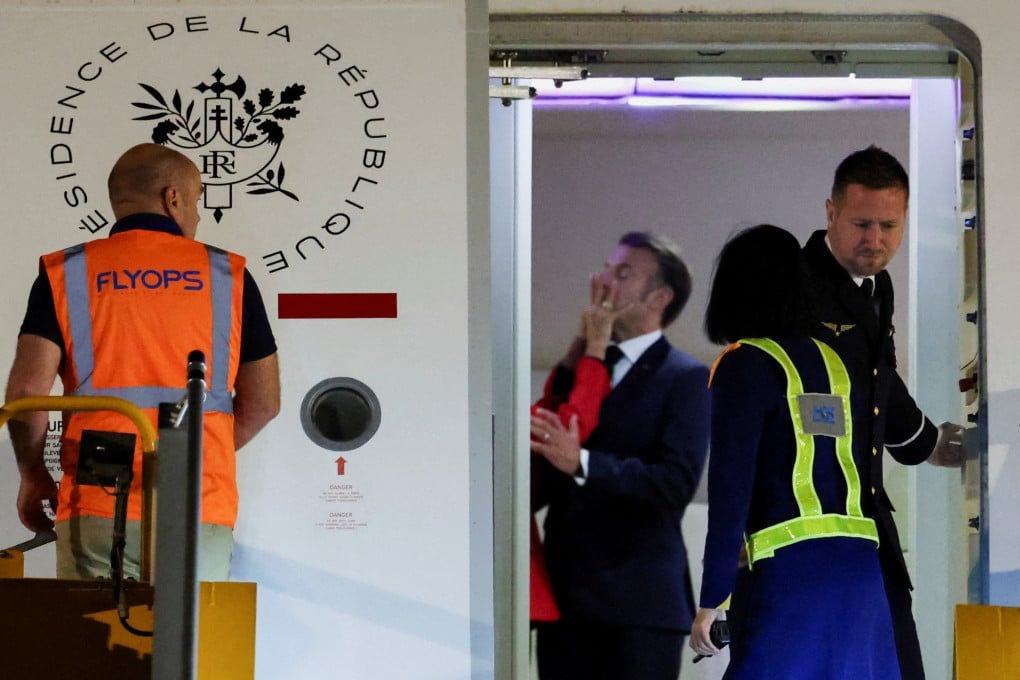 The hand of Brigitte Macron can be seen on the face of French President Emmanuel Macron as the couple arrive in Vietnam. Photo: Reuters