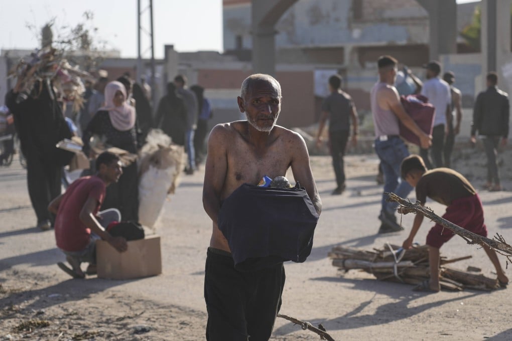 A Palestinian carries a box containing food after aid packages were delivered in Rafah on Tuesday. Photo: AP