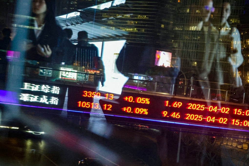 An electronic board shows Shanghai and Shenzhen stock indices as people walk on a pedestrian bridge at the Lujiazui financial district in Shanghai on April 2, 2025. Photo: Reuters