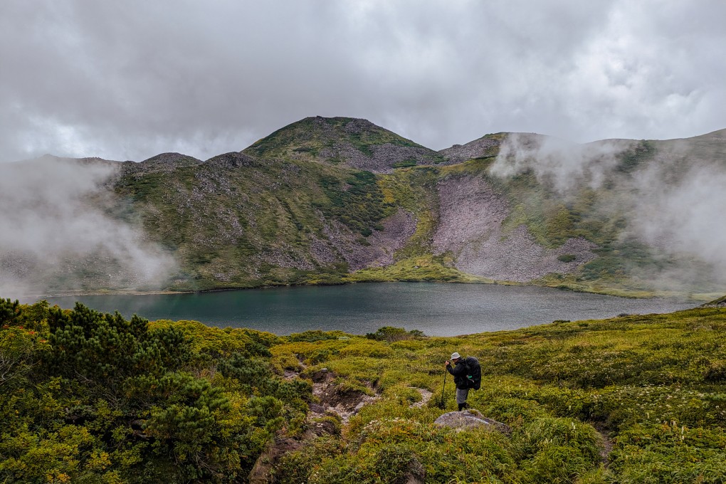 The writer Cameron Dueck trekking past a lake in Daisetsuzan National Park. Photo: Fiona Ching