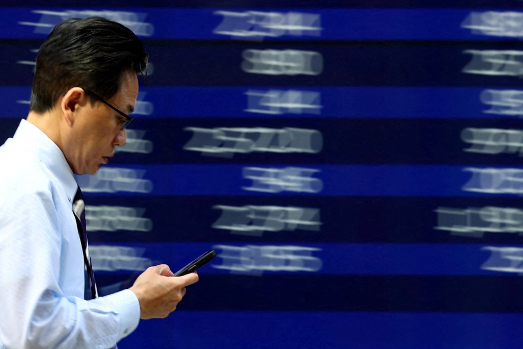 A man walks past an electronic screen displaying stock quotations in Tokyo on April 15. Photo: Reuters