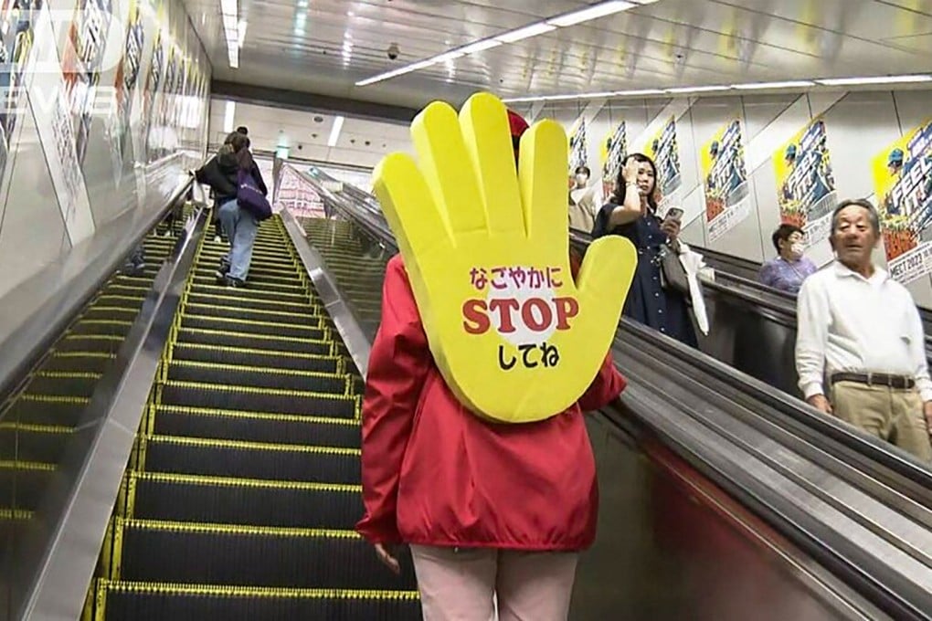 A member of the “Stop and Stand Squad” in Japan’s Nagoya city wears a huge yellow hand as a backpack, emblazoned with a phrase that translates as “Please stop tranquilly”, to stop people from walking up escalators. Photo: ANN News