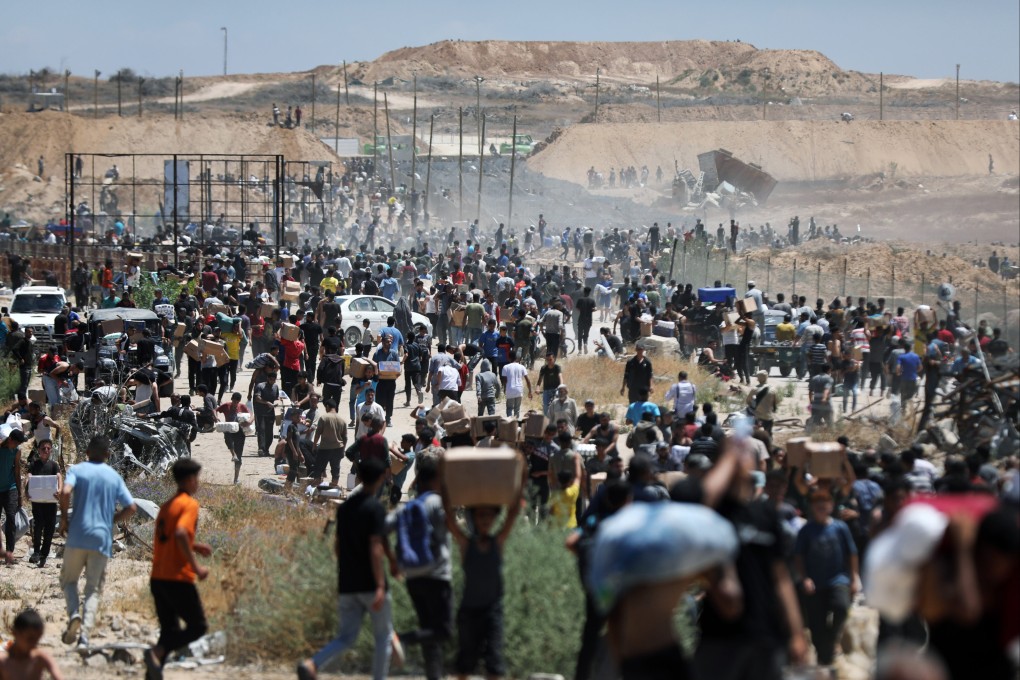 Palestinians walk with aid supplies received from the US-backed Gaza Humanitarian Foundation in Al-Bureij on Thursday. Photo: dpa