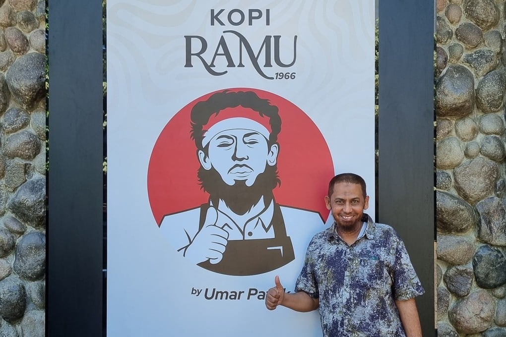 Convicted Bali bomber Umar Patek with a poster advertising his new coffee business in Indonesia. Photo: Aisyah Llewellyn