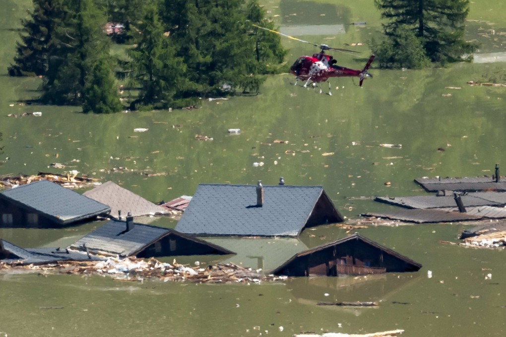 A helicopter flies above debris and destroyed houses of the village of Blatten now submerged after the huge Birch glacier collapsed on Wednesday. Photo: AFP