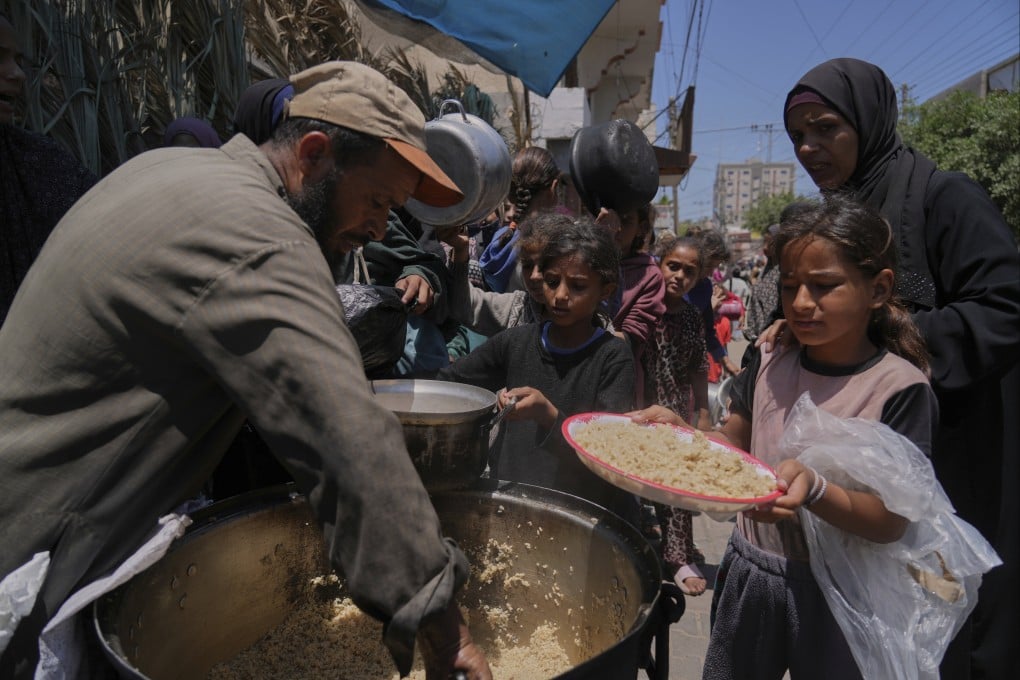 Palestinian children get food at a food distribution kitchen in Deir al-Balah, Gaza Strip, on Friday. Photo: AP