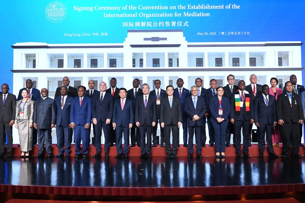 Chinese Foreign Minister Wang Yi (centre, in purple tie) poses with other guests at the signing ceremony of the Convention on the Establishment of the International Organisation for Mediation in Hong Kong on Friday. Photo: Xinhua