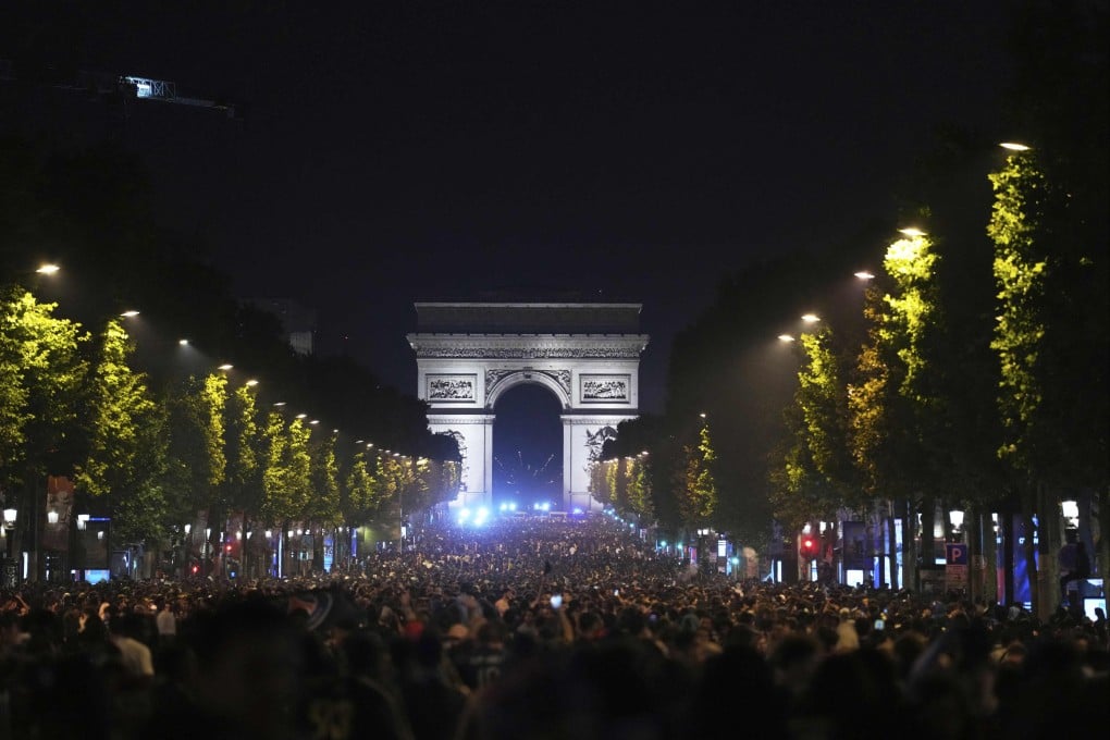 Fans celebrate PSG’s victory on the Champs-Elysees avenue, with the Arc de Triomphe in the background. Photo: AP