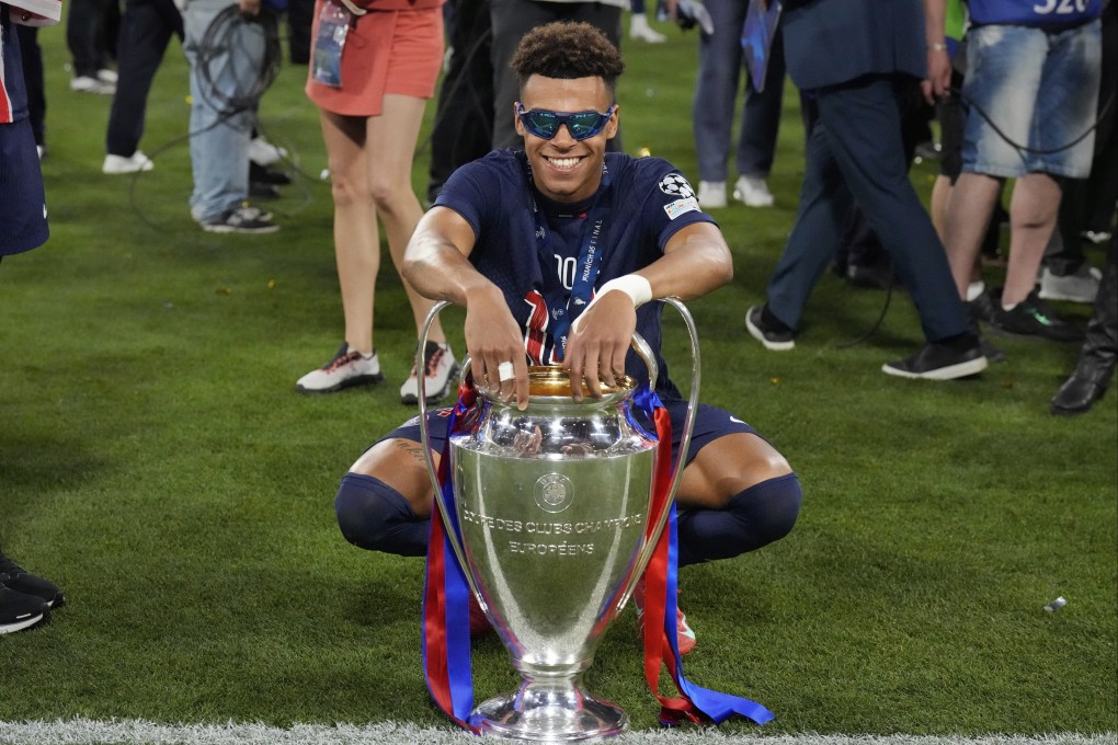 PSG’s Desire Doue poses with the trophy after the Champions League final in Munich. Photo: AP