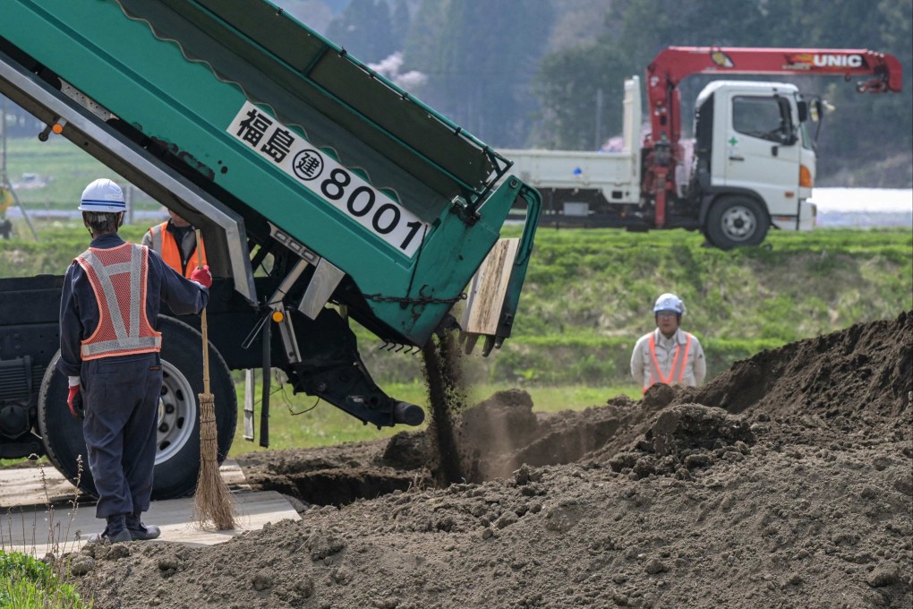 Workers adding clean top soil to a rice field, part of a government pilot project to add fresh earth to recycled and removed soil taken from areas affected by the 2011 nuclear disaster. Photo: AFP