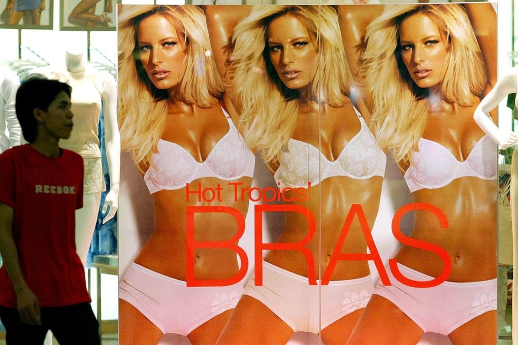 A man walks past a poster advertising women’s underwear at a shopping centre in Kuala Lumpur, Malaysia. Photo: AFP