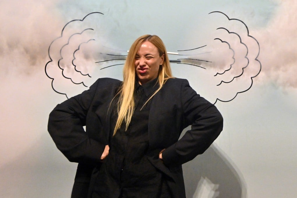 A visitor poses for a picture in front of a drawing on a wall during a visit to the “Third Wind” interactive exhibition in Kyiv, Ukraine, on April 27, 2025. The exhibition aims to help visitors understand their emotions, relieve stress and find their inner child amid the Russian invasion of Ukraine. Photo: AFP