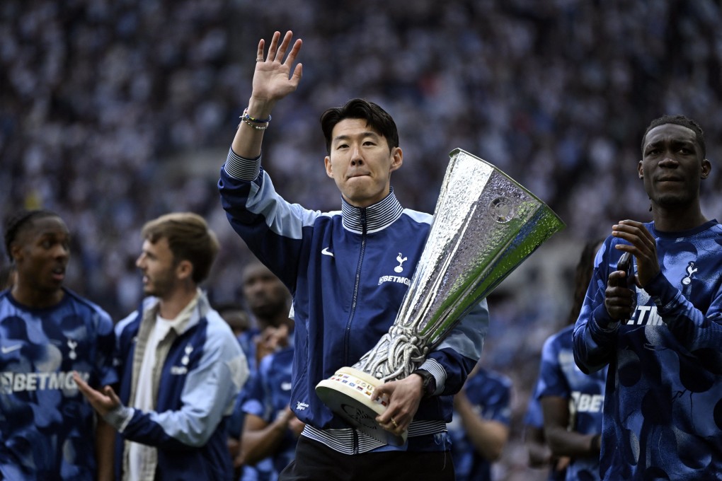 Son Heung-min holds the Europa League trophy as Tottenham Hotspur players celebrate their triumph with their supporters. Photo: Reuters