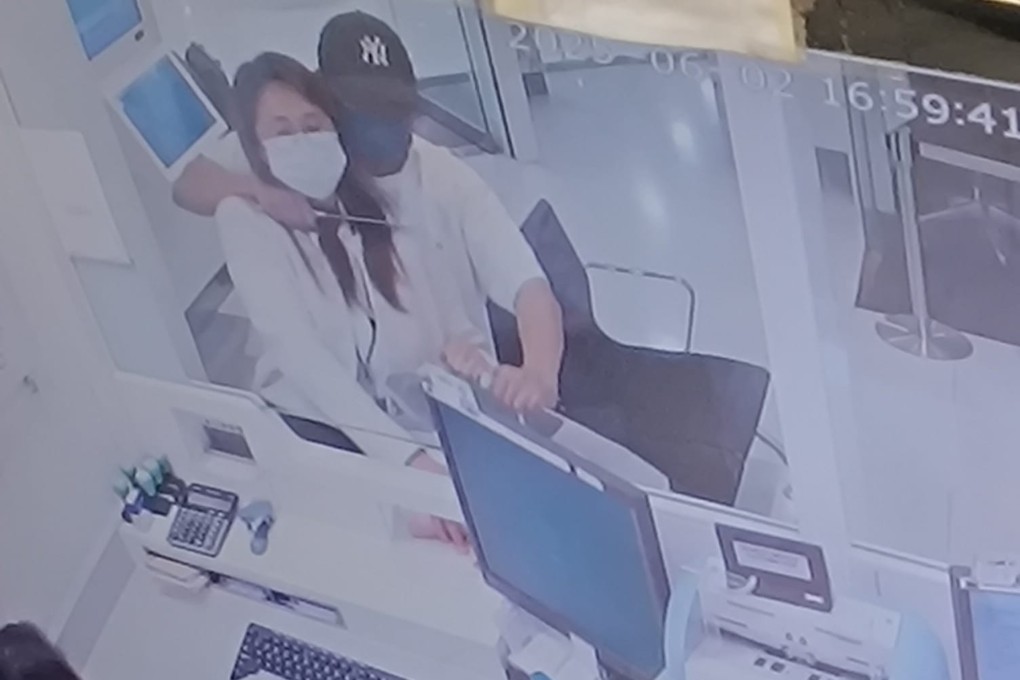 A screen grab of CCTV footage circulating online shows the robber holding a knife at the bank worker’s throat. Photo: Handout