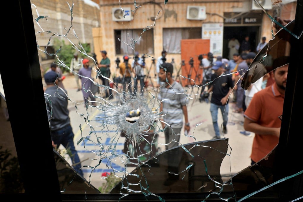 Members of media are seen through a broken glass window inside the premises of the district Malir jail after dozens of prisoners escaped from the jail on the outskirts of Karachi, Pakistan on June 3. Photo: Reuters