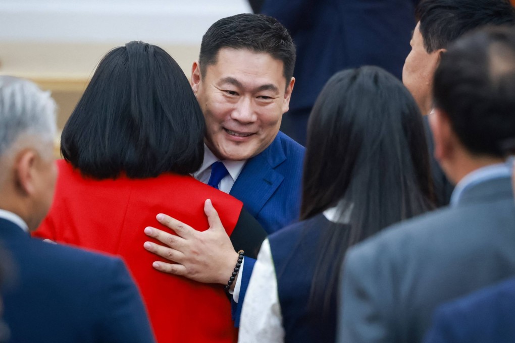Mongolia’s Prime Minister Luvsannamsrain Oyun-Erdene hugs members of parliament after the confidence vote in Ulaanbaatar on Tuesday. Photo: AFP