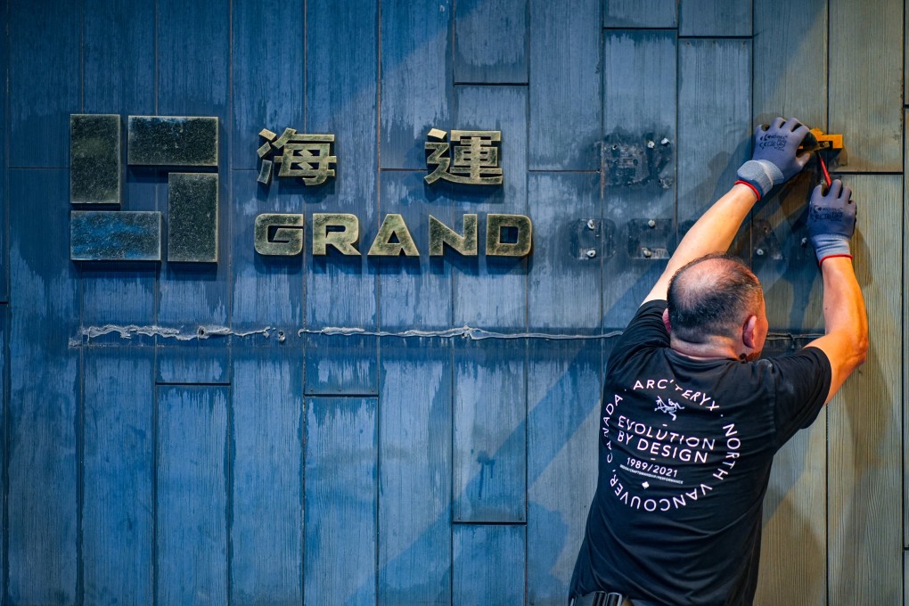 A worker takes down the logo of Grand Ocean cinema in Tsim Sha Tsui earlier this week. Photo: Eugene Lee